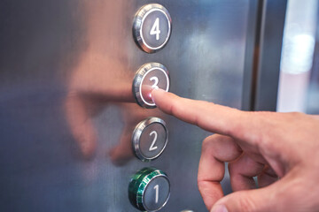 Man hand pointing number 3 button in elevator. Steel interior panel. Change year concept. Waiting new step. Up action. Start claustrophobia moment. Moving click © elenavolf