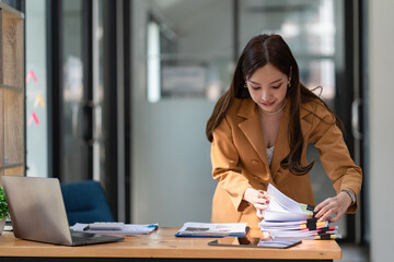 Asian businesswoman arranging documents on her desk