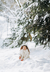 A little girl walks in a snowy park.