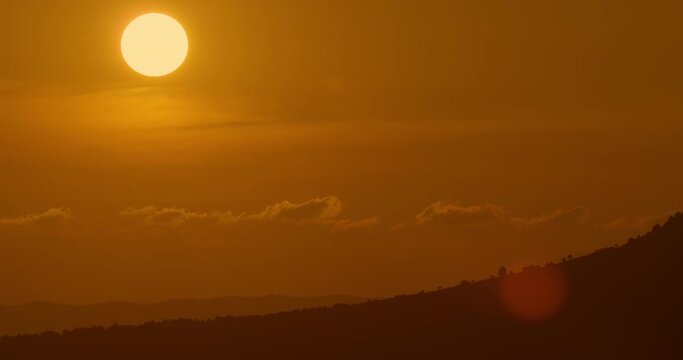 big sun sunset timelapse and cloudless sky, majestic Big Red Hot Sun in mountainous area, the end of something concept, golden hour telephoto lens shot
