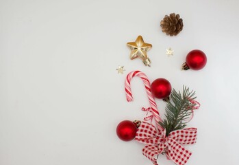 New Year, Christmas concept. Christmas tree branches, cone, lollipop, red balls, gold and red decor on a white background. Top view, copy space, background, postcard