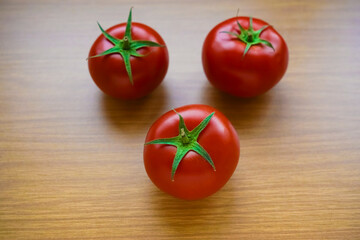 red Cherry tomatoes, whole and halves, on brown textured wooden surface, with a empty copy space. 