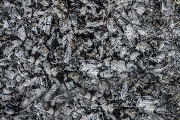 Black and gray charcoal wood. Closeup of burnt black forest floor after bush fire. The cooling coals of the grill. Closeup of coal in a grill. Texture  background.