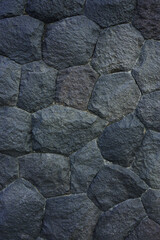 Dark stone wall texture. Black stones and rocks of different shapes, rocks background. 