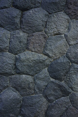 Dark stone wall texture. Black stones and rocks of different shapes, rocks background. 