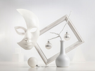 Fototapeta na wymiar Monochrome still life: mask on a white background, picture frame, abstraction