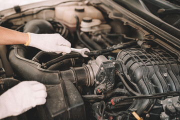 Fototapeta premium Automobile mechanic man checking car damage broken part condition, and repairing vehicle at home garage