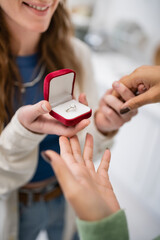 cropped view of smiling lesbian woman making proposal to african american girlfriend on valentines day.