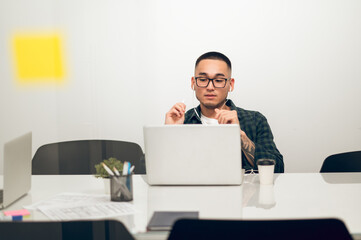 Office worker seated at the laptop having a Skype conversation