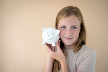 cool young girl in front of brown background holding piggy bank in her hands and wearing brown t-shirt