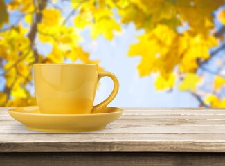 Ceramic cup of hot drink on autumn background