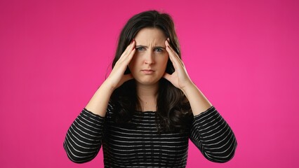 Sick tired headache migraine exhausted displeased pretty woman 20s posing isolated on pink background studio. Put hands on head rub temples