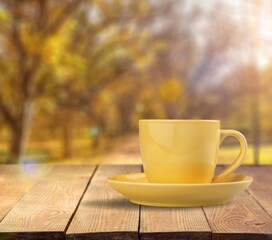 Naklejka na ściany i meble Ceramic cup of hot drink on autumn background