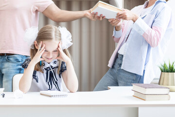 Young parents help their daughter with her lessons, but girl hate education and learning something