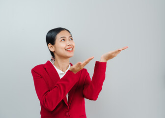 Pretty lovely manager lady successful business asian women in red suit isolated over background. Palm up her hands