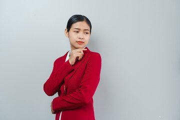 Pretty lovely manager lady successful business asian women in red suit isolated over background. Thinking and looking for something