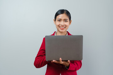 Pretty lovely manager lady successful business asian women in red suit isolated over background. Holding and using laptop computer