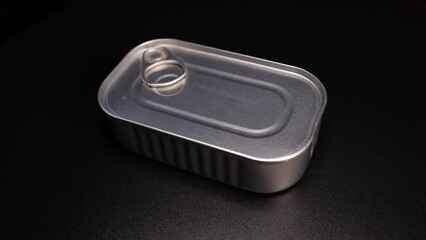 metallic tin can with canned food is spinning on a black background. Tourist food, military or humanitarian aid - Powered by Adobe