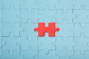 Red puzzle on blue puzzles. The concept of loneliness, unity, confrontation.