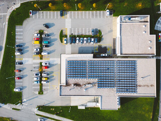 Top down view of an discount retailer chain with solar panels on the rood and a parking lot on the side © VisualProduction