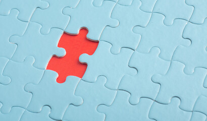 Red puzzle on blue puzzles. The concept of loneliness, unity, confrontation.