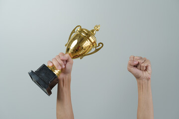 Close up man hands holding champion golden trophy isolated over background.