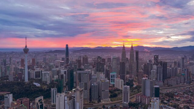 Aerial Drone Time lapse: Kuala Lumpur city view during dawn overlooking the city skyline with busy city streets in Federal Territory, Malaysia. Prores 4KUHD Timelapse.