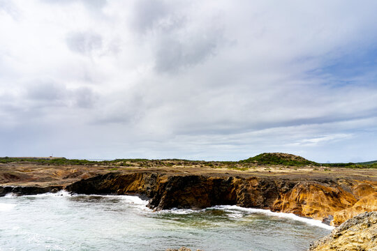 Multicolor Sand Landscape With Ocean And Grey Sky And Clouds