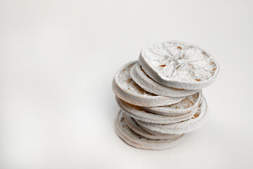 dried sweet oranges in slices of white color lie in a column on top of each other on a white background. for labels, signs, postcards, announcements and more