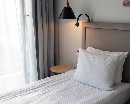 Made Up Bed In A Hotel Room With Night Lamps