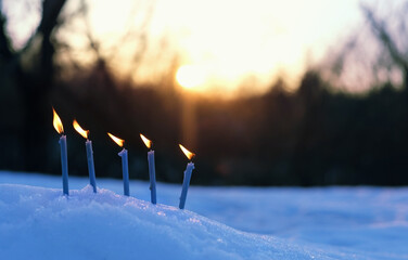 Burning candles on snow, magic winter evening scene. beautiful winter natural background with...