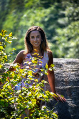 Photographs of model in nature relaxing on large rock