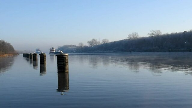 Frachtschiff und Containerschiff fahren im Winter durch den Nord-Ostsee-Kanal