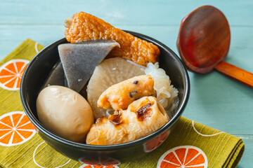 黒い器に入ったおでんと杓子