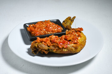 Ayam geprek sambal indonesian food or geprek fried chicken with sambal hot chili sauce. Selective Focus
