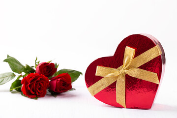 Heart shaped gift box and bouquet of red roses