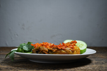 Ayam geprek sambal indonesian food or geprek fried chicken with sambal hot chili sauce. Selective Focus