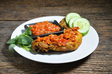 Ayam geprek sambal indonesian food or geprek fried chicken with sambal hot chili sauce. Selective Focus