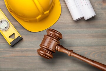 Labor law concept. Wooden Judge gavel and blueprint plans - obrazy, fototapety, plakaty