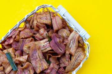 Banana slice chips on yellow background.