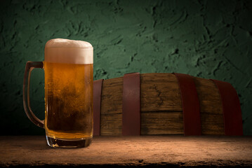 mug of beer, wheat ears, hops and beer barrel on a wooden background. High quality photo