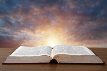 Old open book on wooden desk