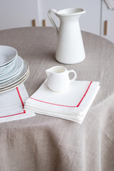 white porcelain tableware plates on grey table cloth in kitchen at home
