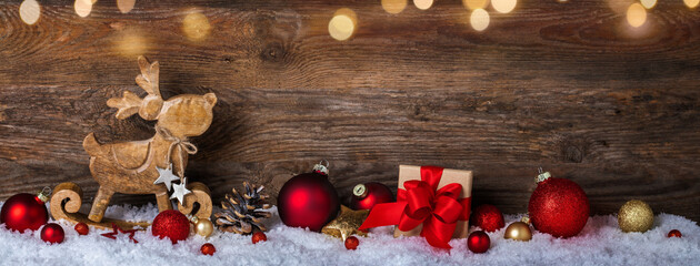 Fröhliche Weihnachten, Panorama, Banner. Hintergrund mit Holz, Schnee, Geschenk, Elch, Bokeh Lichtern.  Weihnachtsdekoration, Weihnachtsmotiv mit Textraum als Grußkarte, Weihnachtskarte, Neujahrsgruß - 553809310