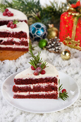 Red Velvet Cake is a traditional red chocolate cake topped with white buttercream and decorated with a Christmas wreath of candied cranberries and rosemary.