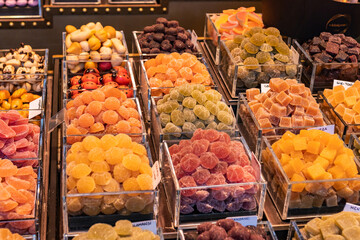Candy store at the Boqueria market in Barcelona (Spain), selective focus on the center of the image.
