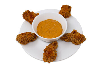 Hot crunchy delicious golden brown fried chicken drumsticks with peri peri dip on a white plate