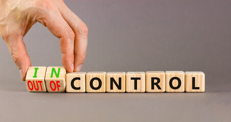 In or out of control symbol. Concept words In control and Out of control on wooden cubes....