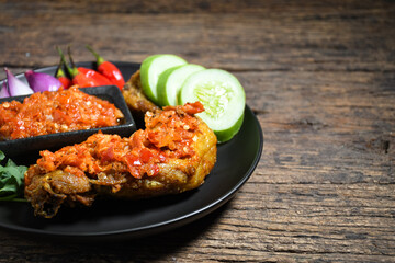 Ayam geprek sambal indonesian food or geprek fried chicken with sambal hot chili sauce served steam rice. Ayam Geprek is a typical Indonesian flour fried chicken dish that is pulverized or crushed