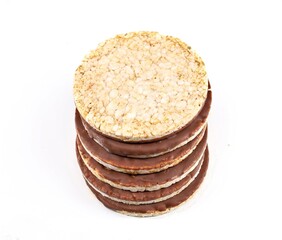 Stack of puffed rice diet crackers with chocolate on white background. Circle shaped, copy space. 